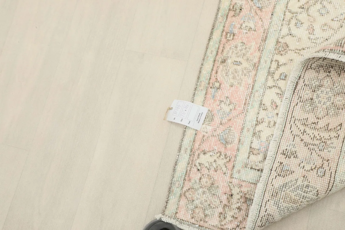 Close-up of the rug's underside, showcasing the hand-knotted construction and a product tag.