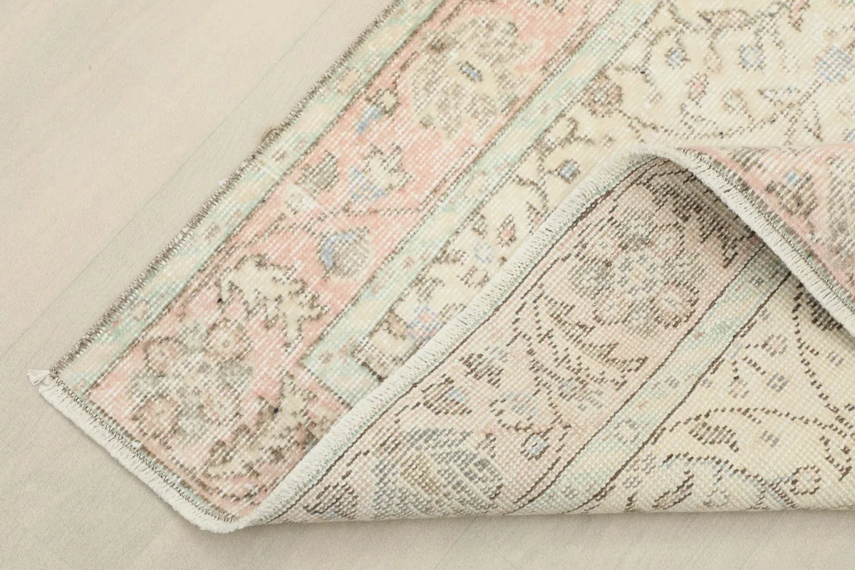 Rug corner folded back to reveal the back of the hand-knotted wool on cotton foundation.