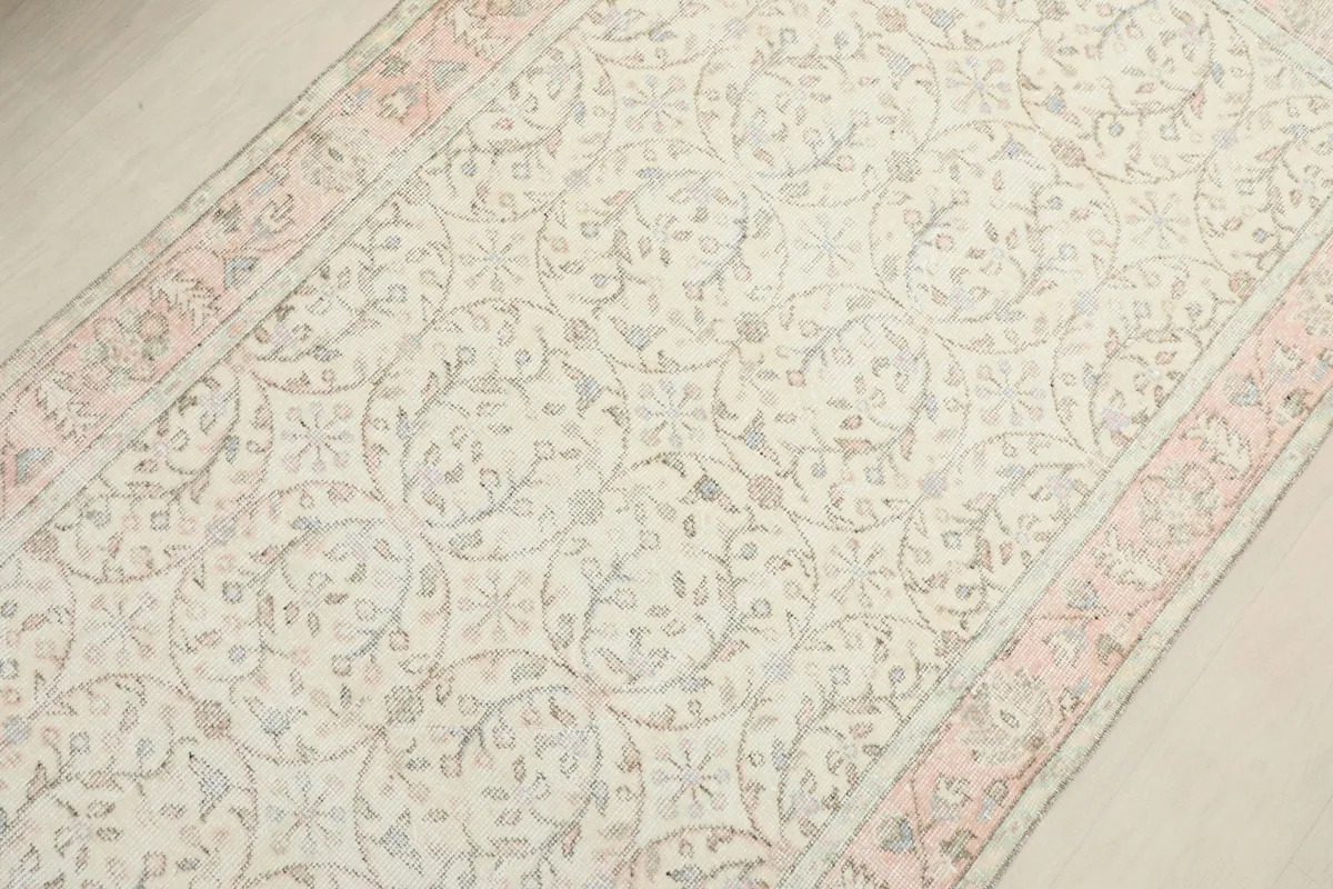 Overhead shot focusing on the central part of the rug, revealing the intricate floral and geometric patterns.