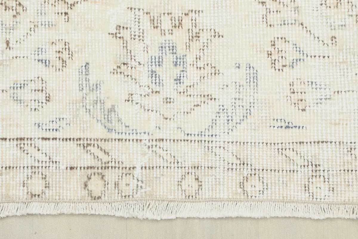 Close-up of the rug's border with intricate floral and geometric elements and fringe