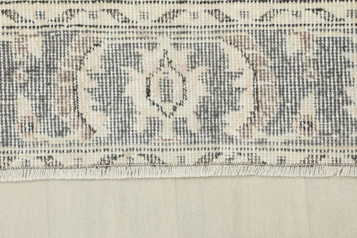 Close-up of the rug's fringe and a section of the border pattern, showing the wool texture.