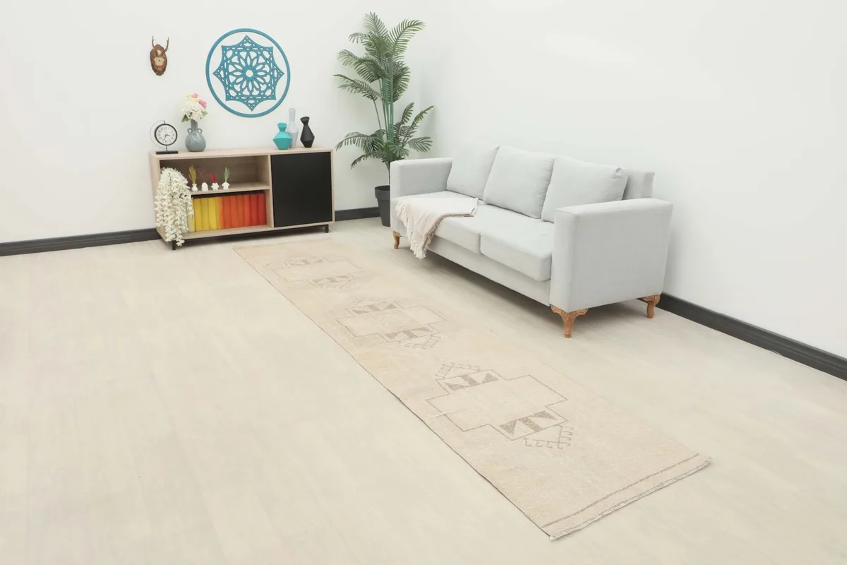 Long view of the tan runner rug in a modern living space with a light gray sofa and minimalist decor.