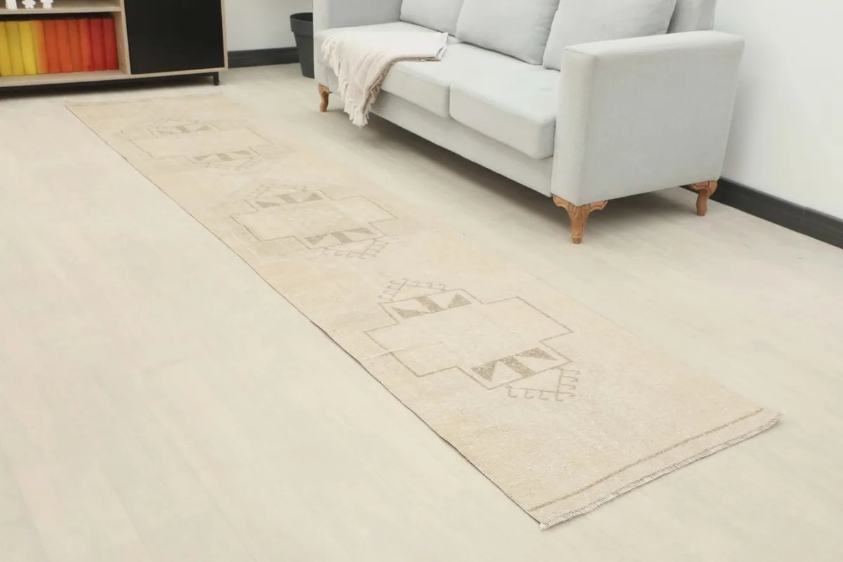 Angled view of the vintage runner rug extending along a hallway next to a sofa.