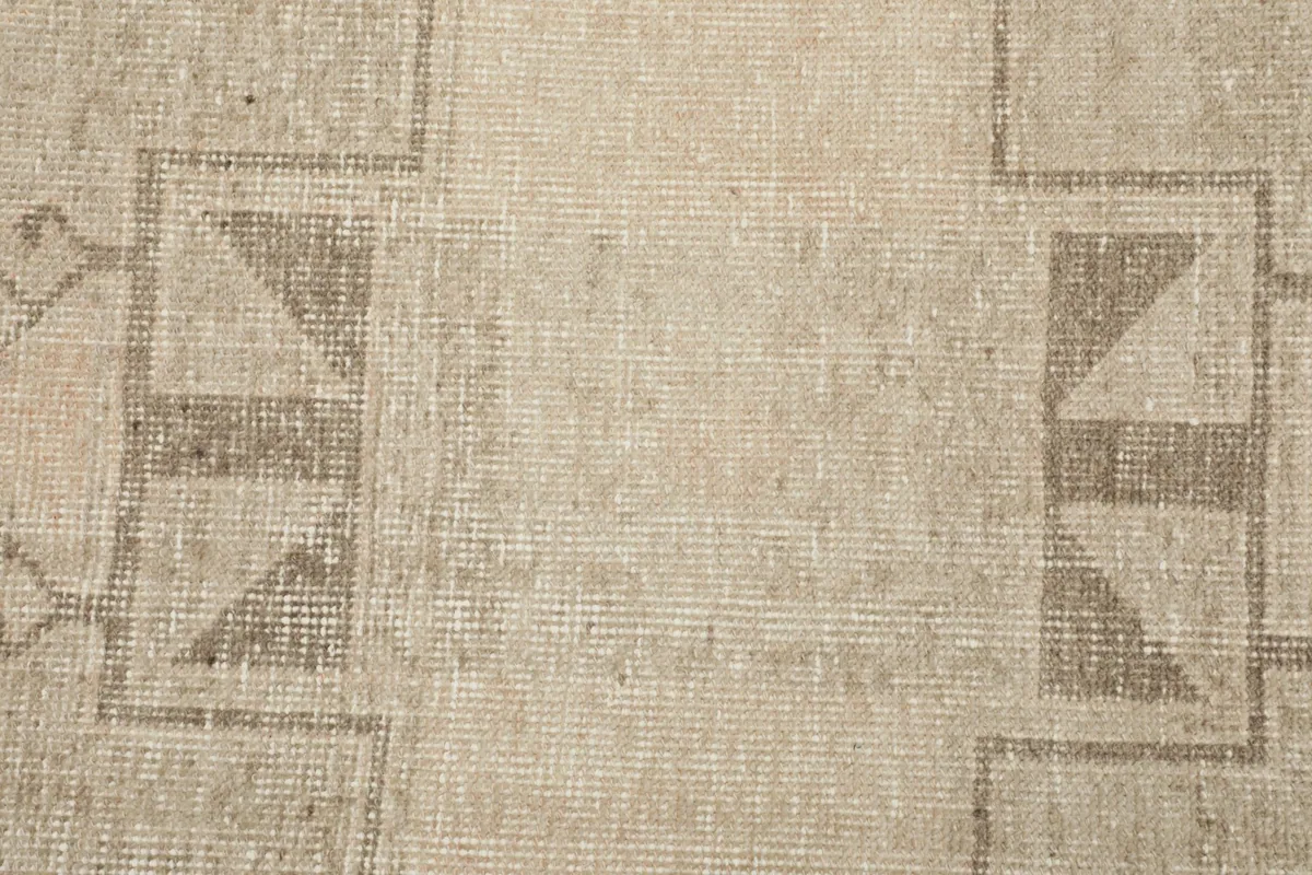 Close-up of the wool pile and distressed surface, showing the subtle color variations and hand-knotted texture.