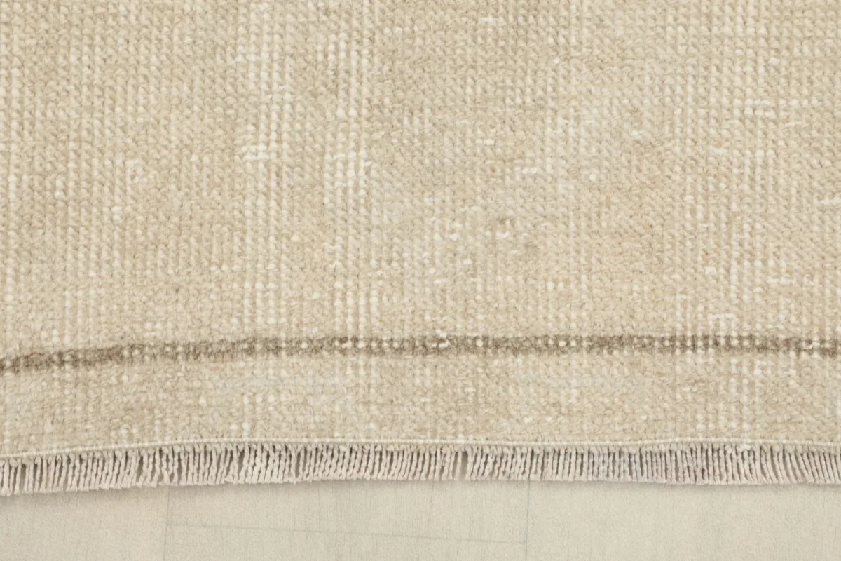 Close-up of the short, natural fringe and the finished edge of the hand-knotted wool runner.