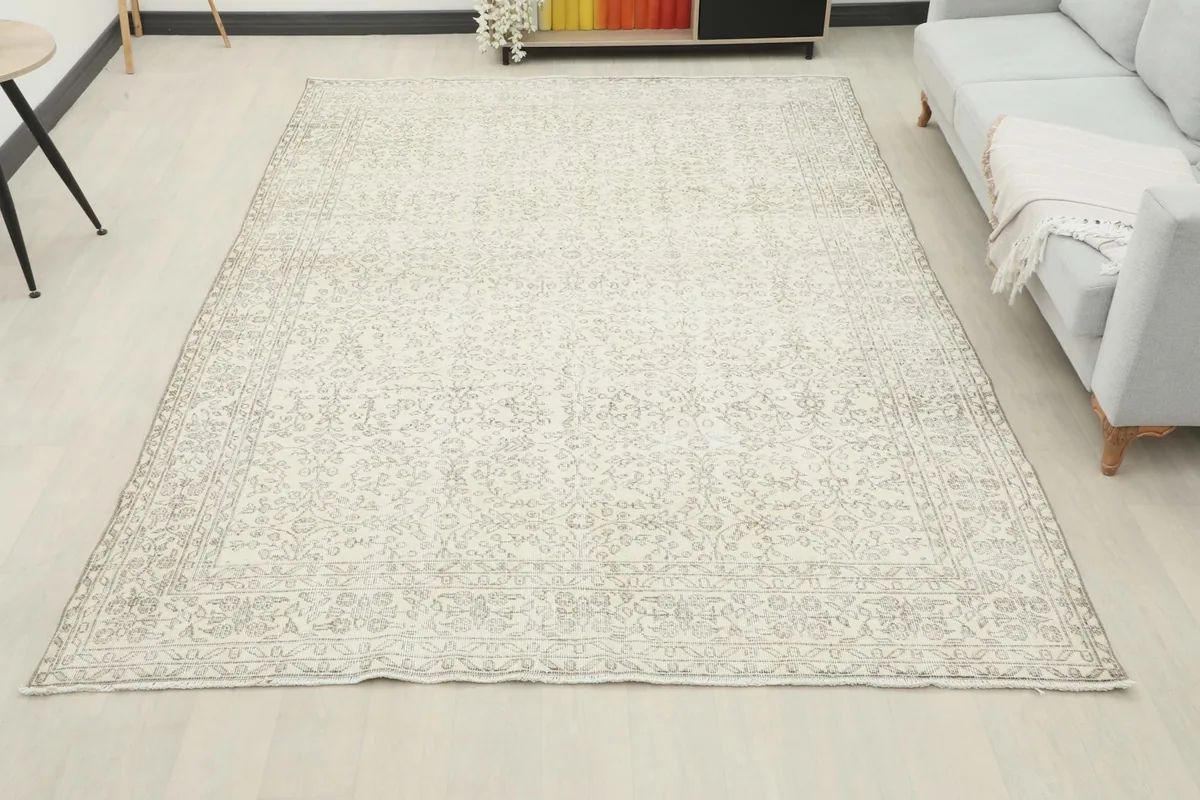 Full room view of the 7'1" x 10'5" cream and gray vintage rug in a light-filled space.