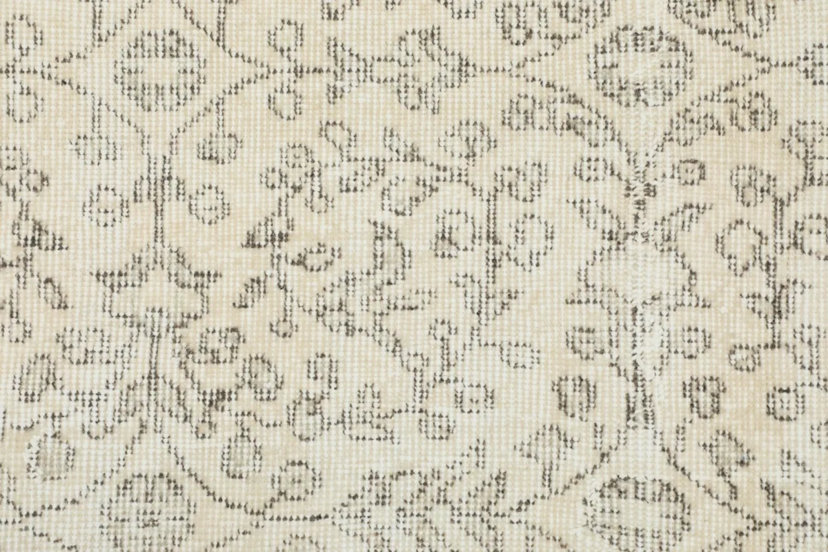 Close-up showing the texture and faded gray details of the hand-knotted wool pile.