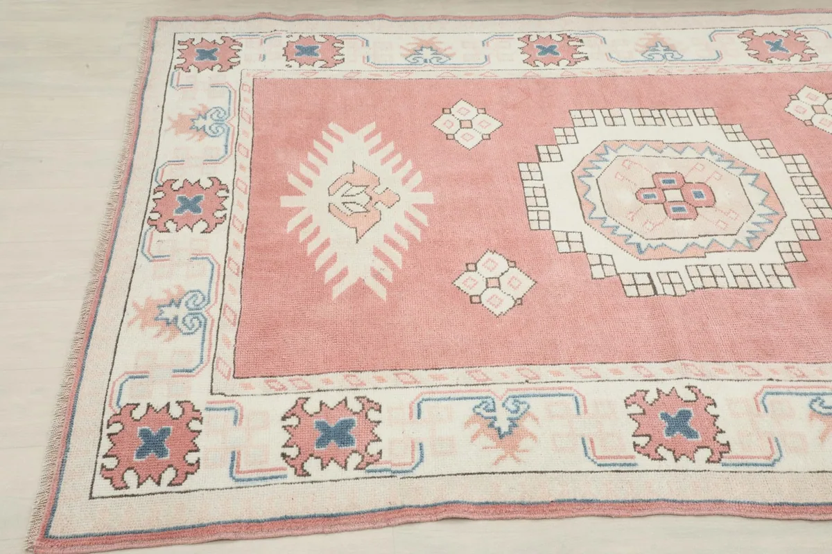 Corner view of the rose rug showing the border motifs and soft pile texture
