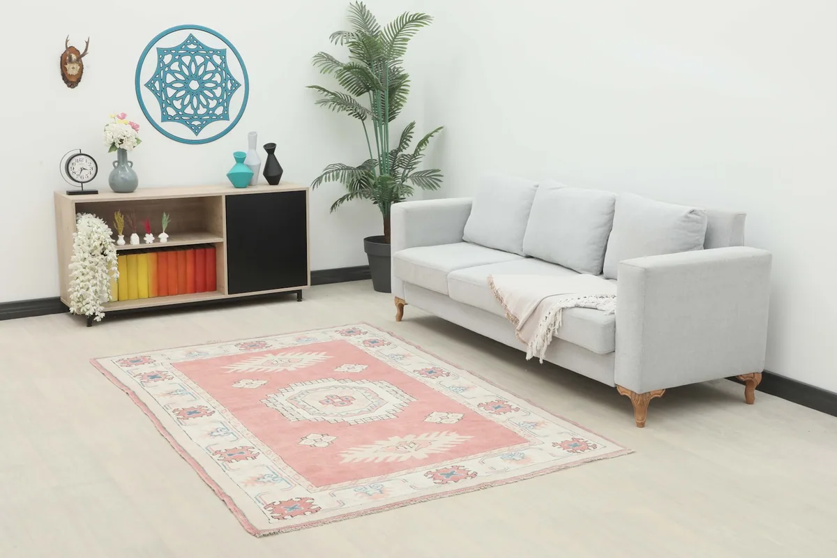 Rose tribal medallion rug placed in a living room setting with a light gray sofa