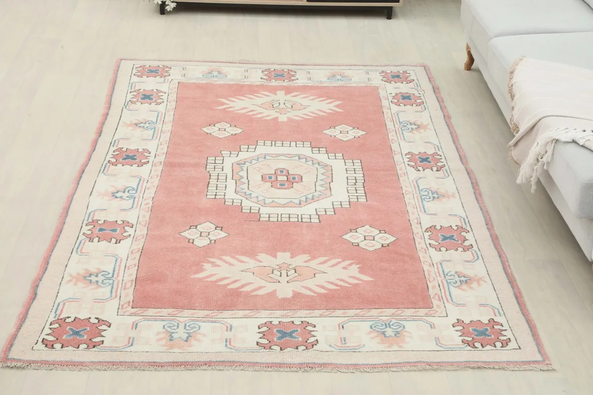 Overhead view of the rose tribal medallion rug in a room setting with a sofa