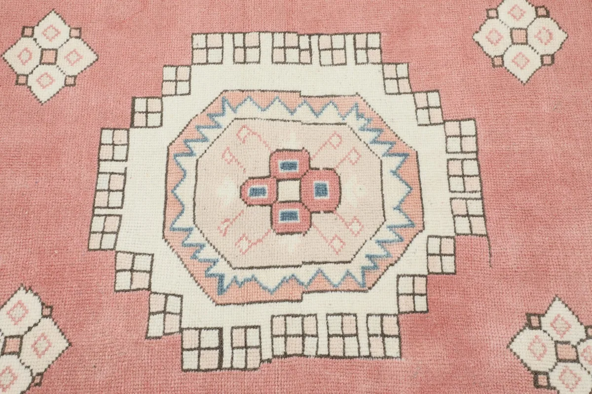 Close-up of the central medallion and surrounding geometric motifs on the rose field