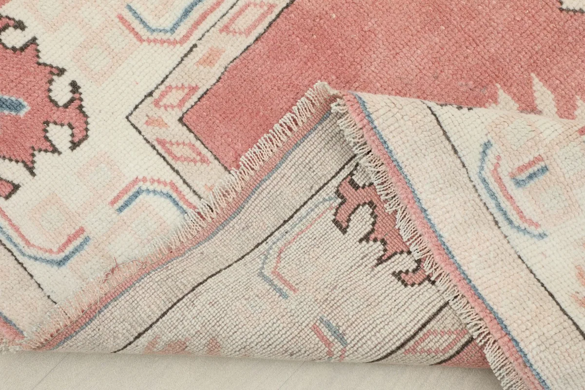 Close-up of the rug's edge, showing the wool pile and cotton foundation