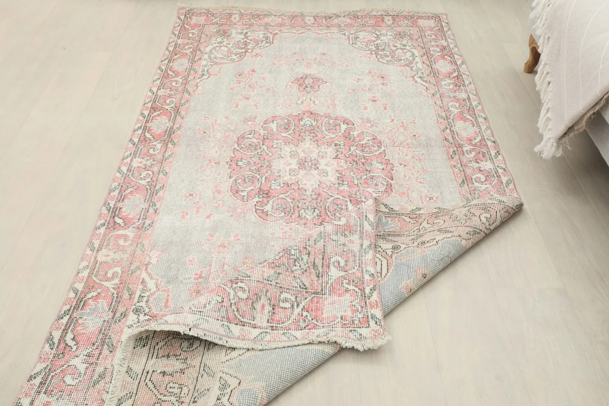 Partial fold of the rug showing the reverse side and the construction of the cotton foundation.