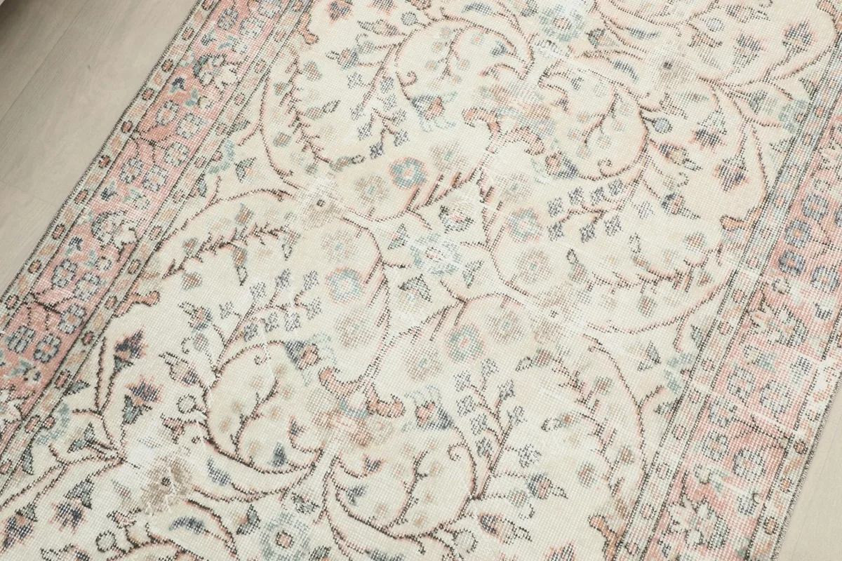 Detailed view of the central floral pattern on the ivory field of the vintage Anatolian rug.