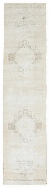 Full overhead view of the 2'8" x 11'3" ivory and beige vintage Anatolian runner rug with geometric medallions.
