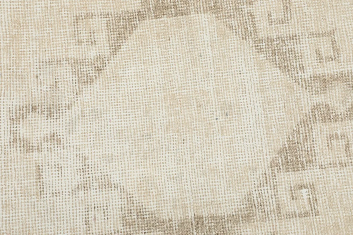 Tight detail of the faded geometric pattern and the texture of the wool pile on cotton foundation.