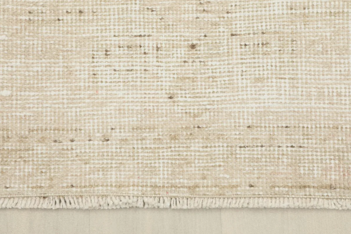 Close-up of the rug's fringe and the overall texture of the low pile, showing slight variations in color.