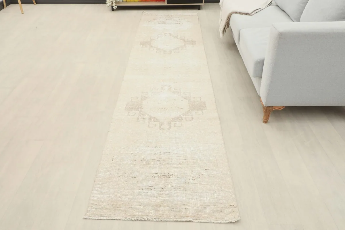 Full overhead shot of the ivory and beige runner rug laid out, highlighting its complete design.