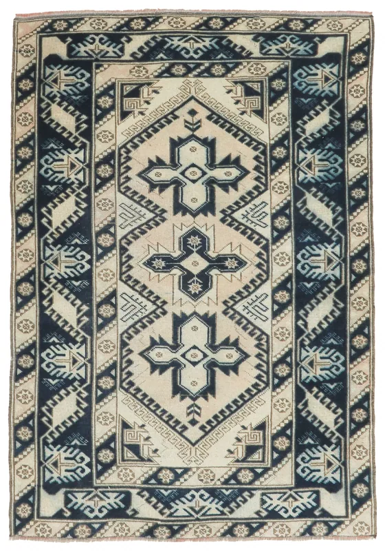 Full top view of the 4x6 vintage Anatolian rug with ivory field and navy geometric patterns