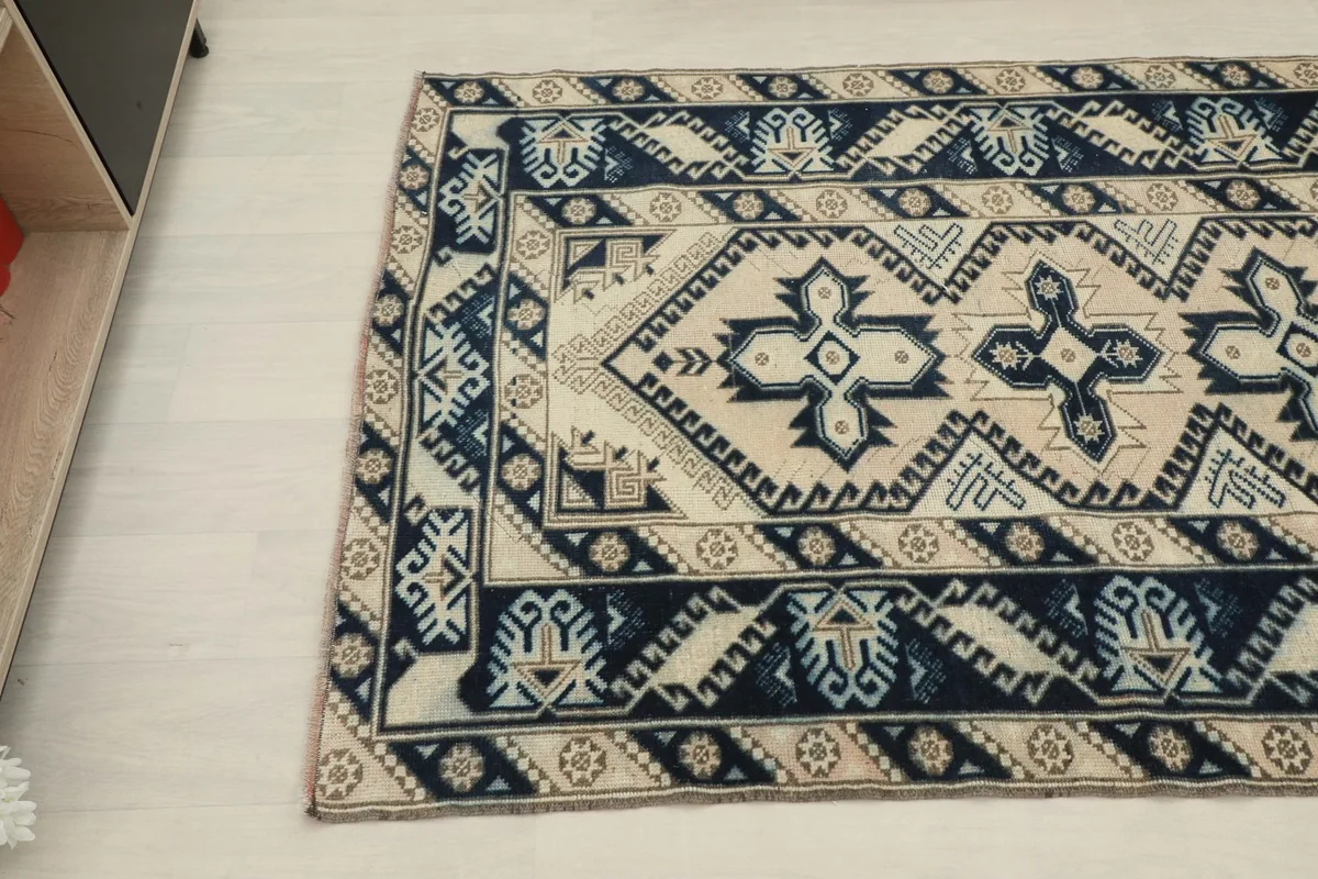 Angled view focusing on the lower left corner of the rug, showing the geometric motifs