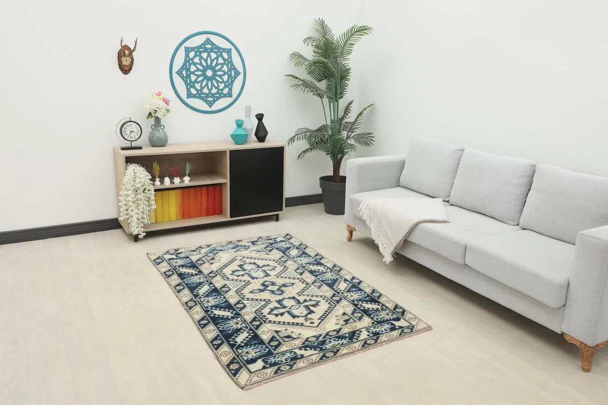 Vintage Anatolian rug placed in a modern living room setting next to a sofa and cabinet