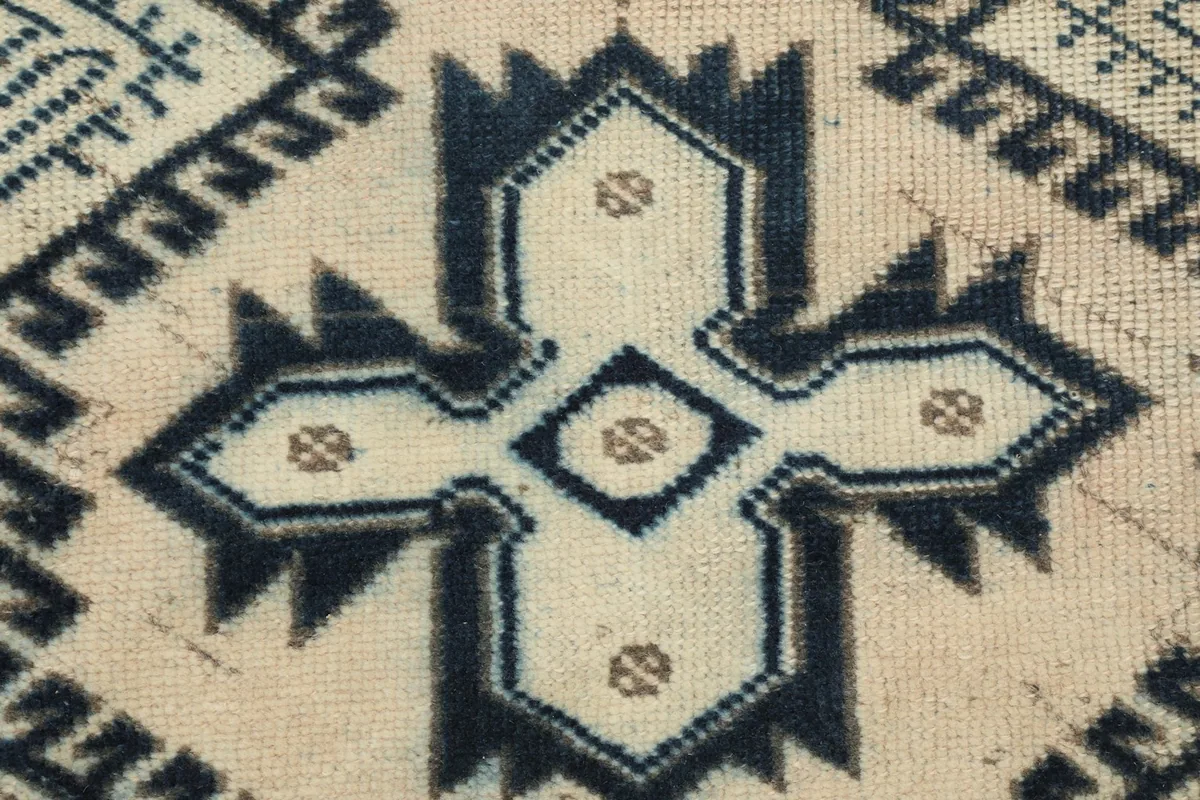 Detailed close-up of a central geometric motif in navy and ivory with subtle beige accents