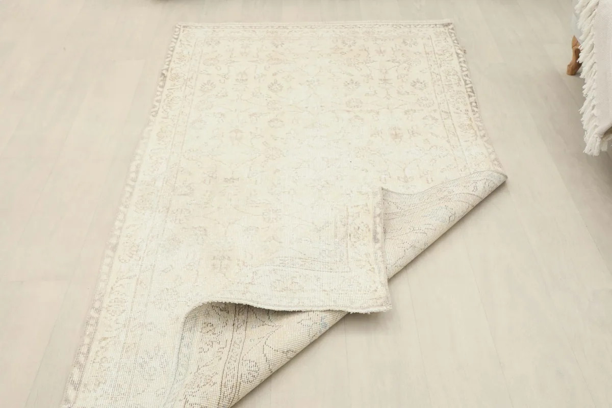 Rug partially folded, showcasing its flexibility and the texture of the wool pile