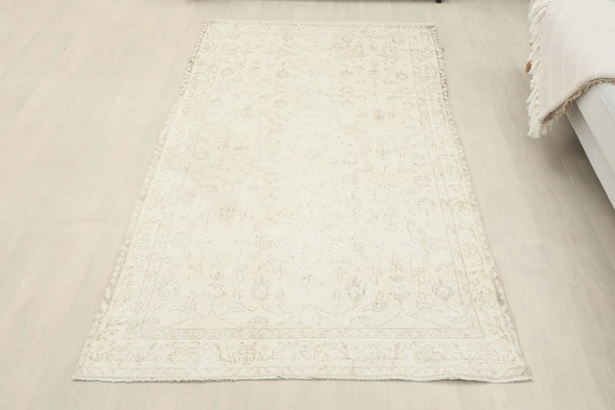 Full overhead view of the ivory vintage rug on a light floor in a room setting