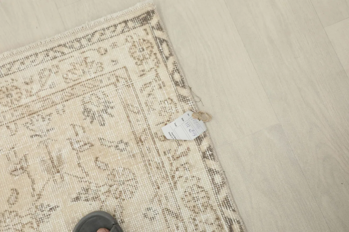 Corner of the rug with a small tag near the border, showing the texture