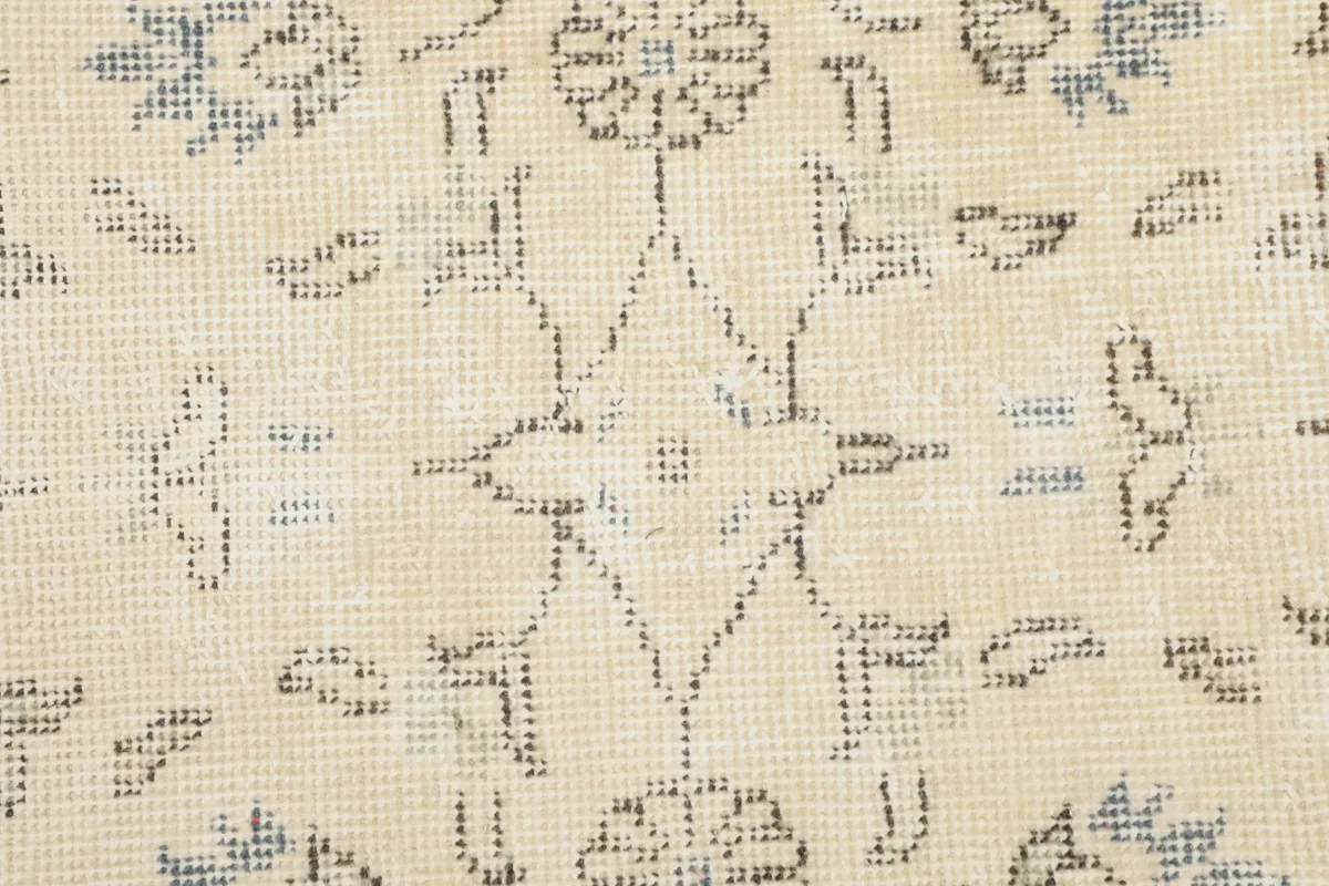 Extreme close-up of the wool pile, showing the hand-knotted texture and faded blue and gray threads.