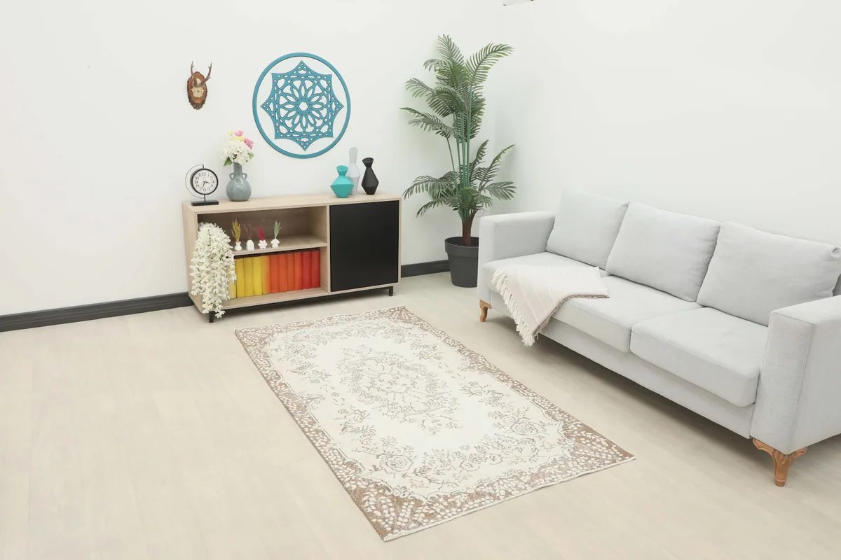 Ivory and tan rug displayed in a modern living room setting with a light sofa