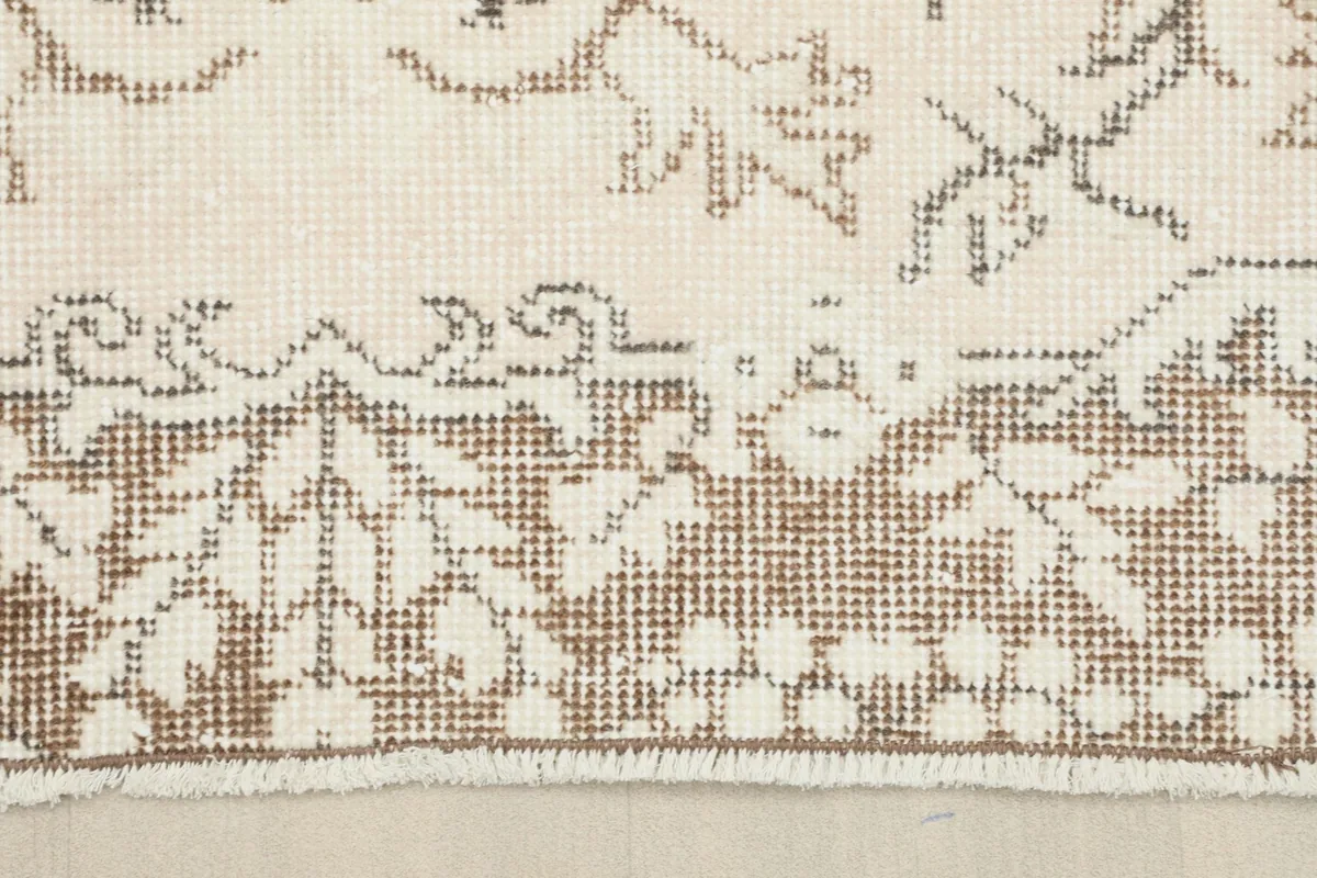 Detail of the rug's border pattern and the short, even fringe