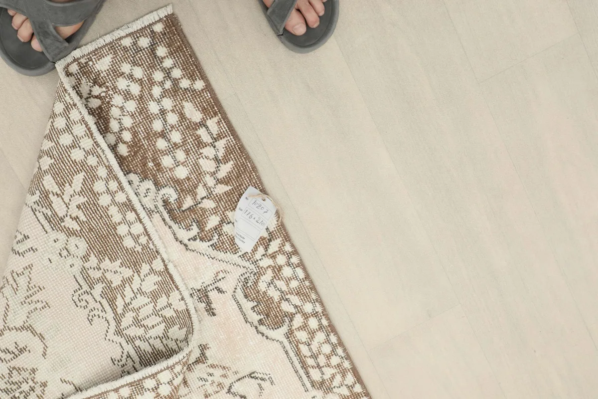 Close-up of the rug's reverse side with a tag, showing the knotting and foundation