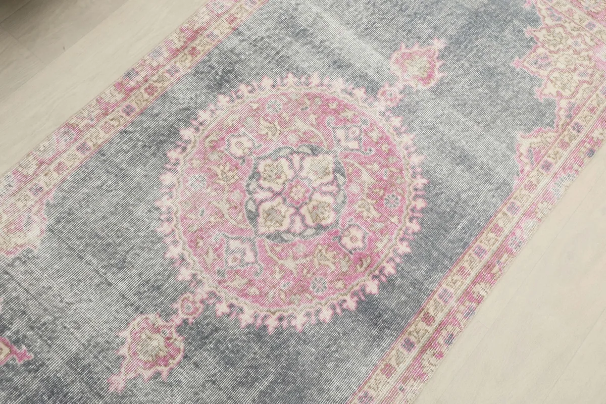 Overhead angled shot focusing on the central pink medallion and gray field