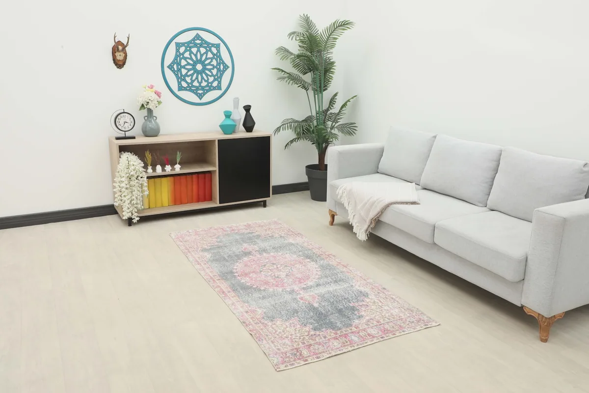 Small gray and pink area rug placed in a modern living room setting