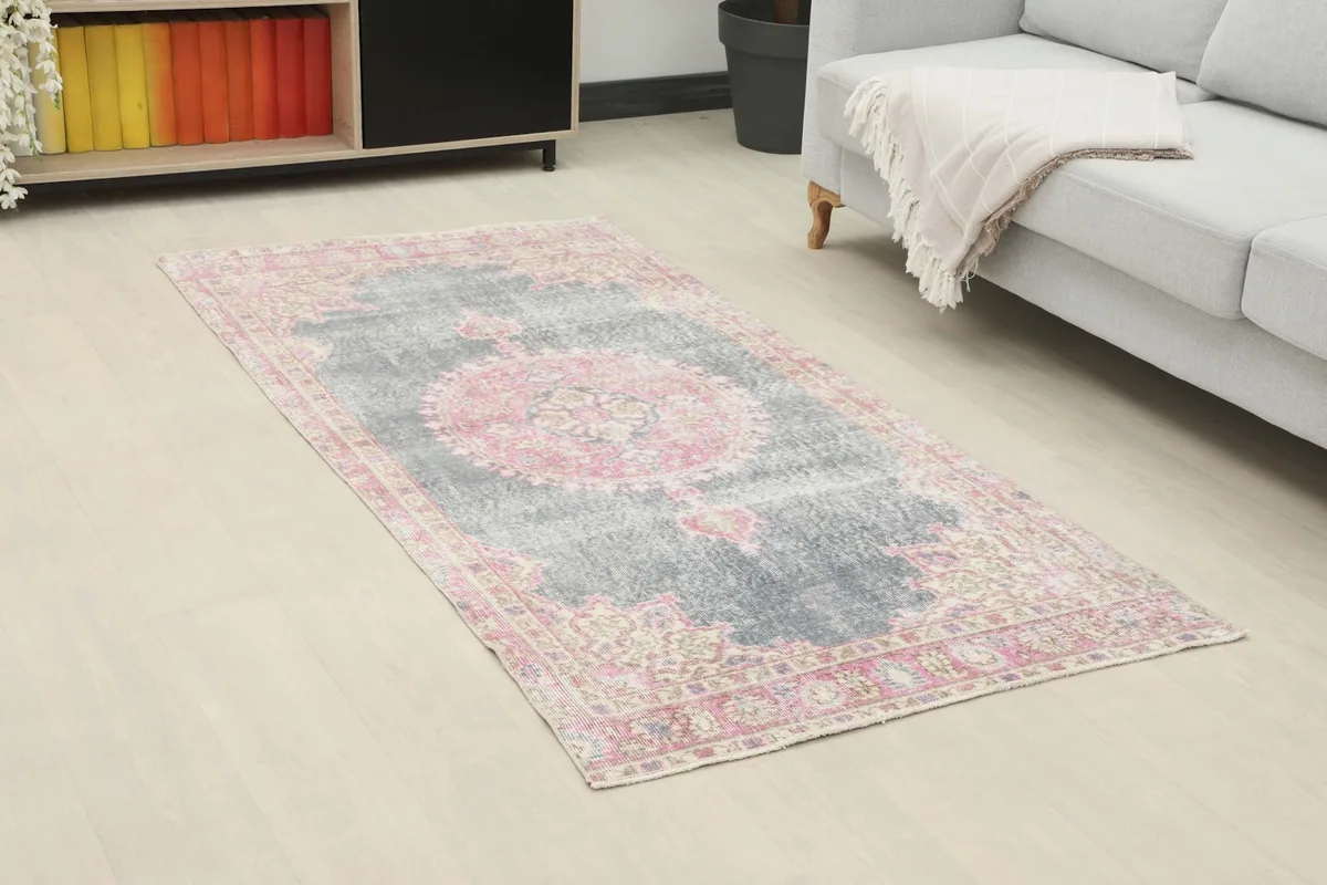 Angled view of the gray and pink vintage rug in a living room