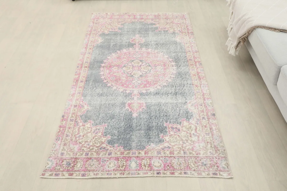 Full overhead view of the gray and pink vintage rug laid flat on the floor