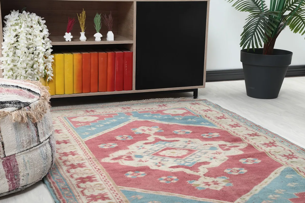 Close-up view of the rug in a room, showing its proximity to a decorative pouf and wooden cabinet.