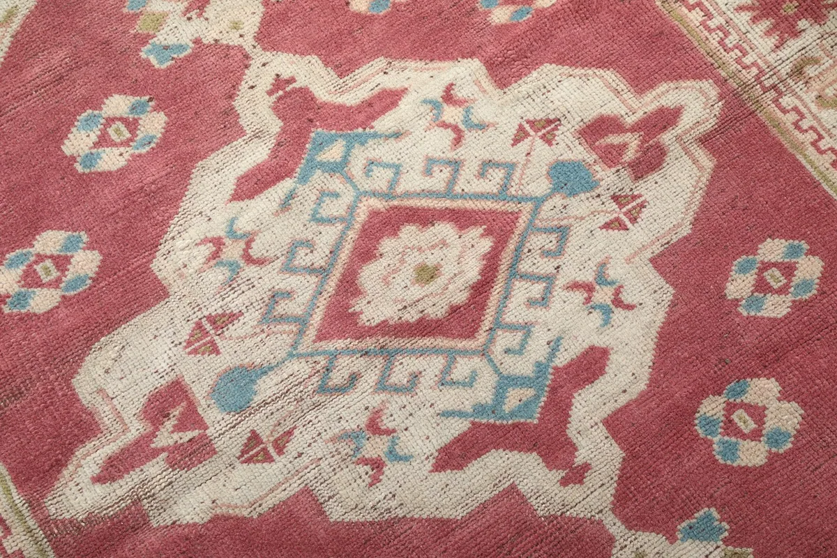 Detailed view of the central design, showing the texture and subtle color variations of the wool pile.