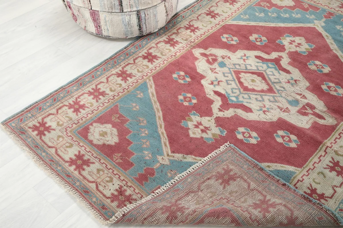 Rug corner folded back, revealing the reverse side of the hand-knotted wool pile and cotton foundation.