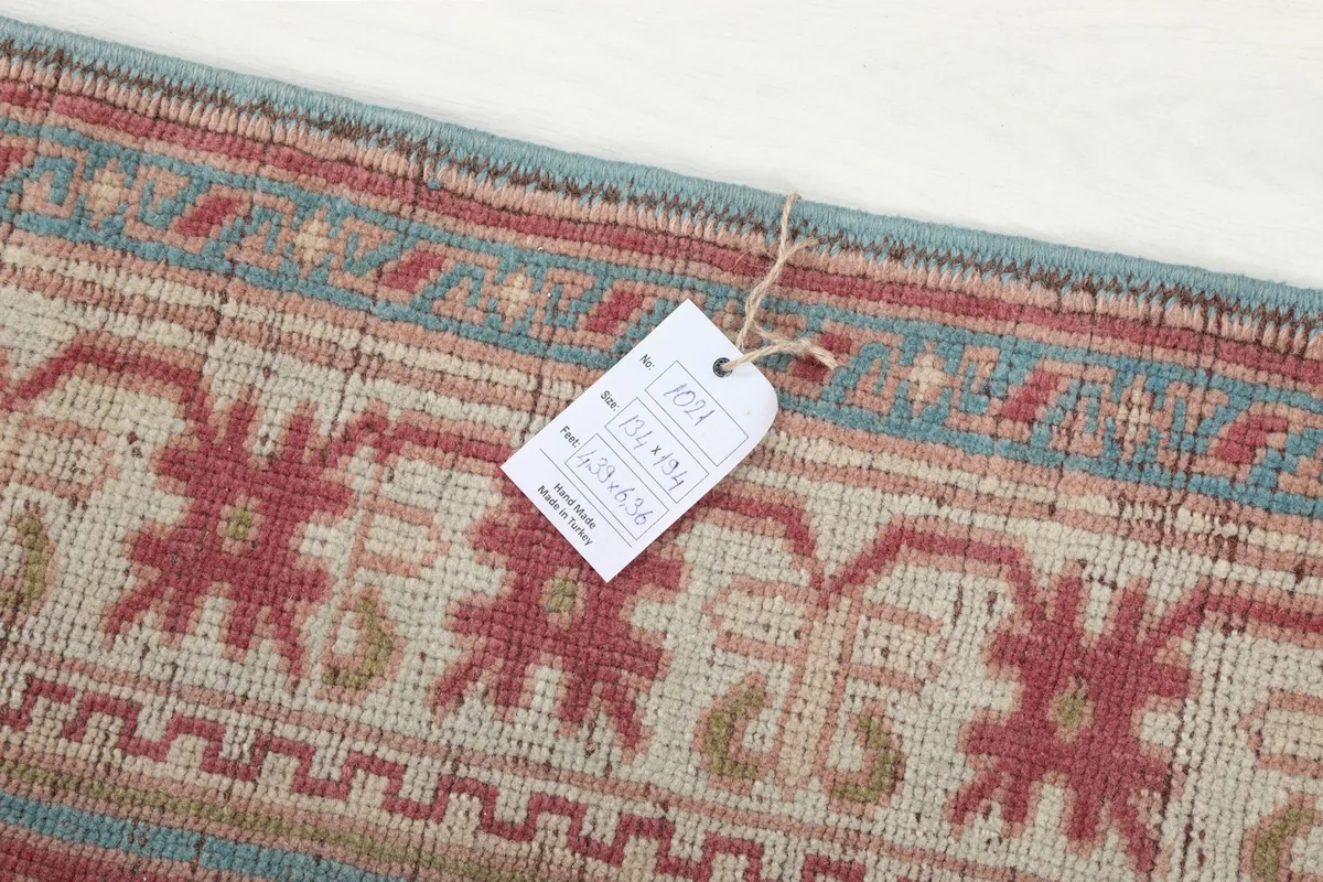 Close-up of a tag attached to the rug, showing product information and dimensions.