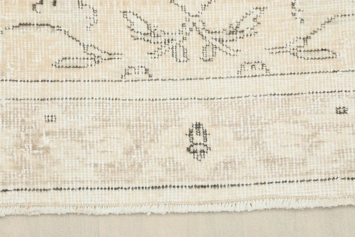 Close-up of the rug's border, showing the hand-knotted texture and a small section of fringe
