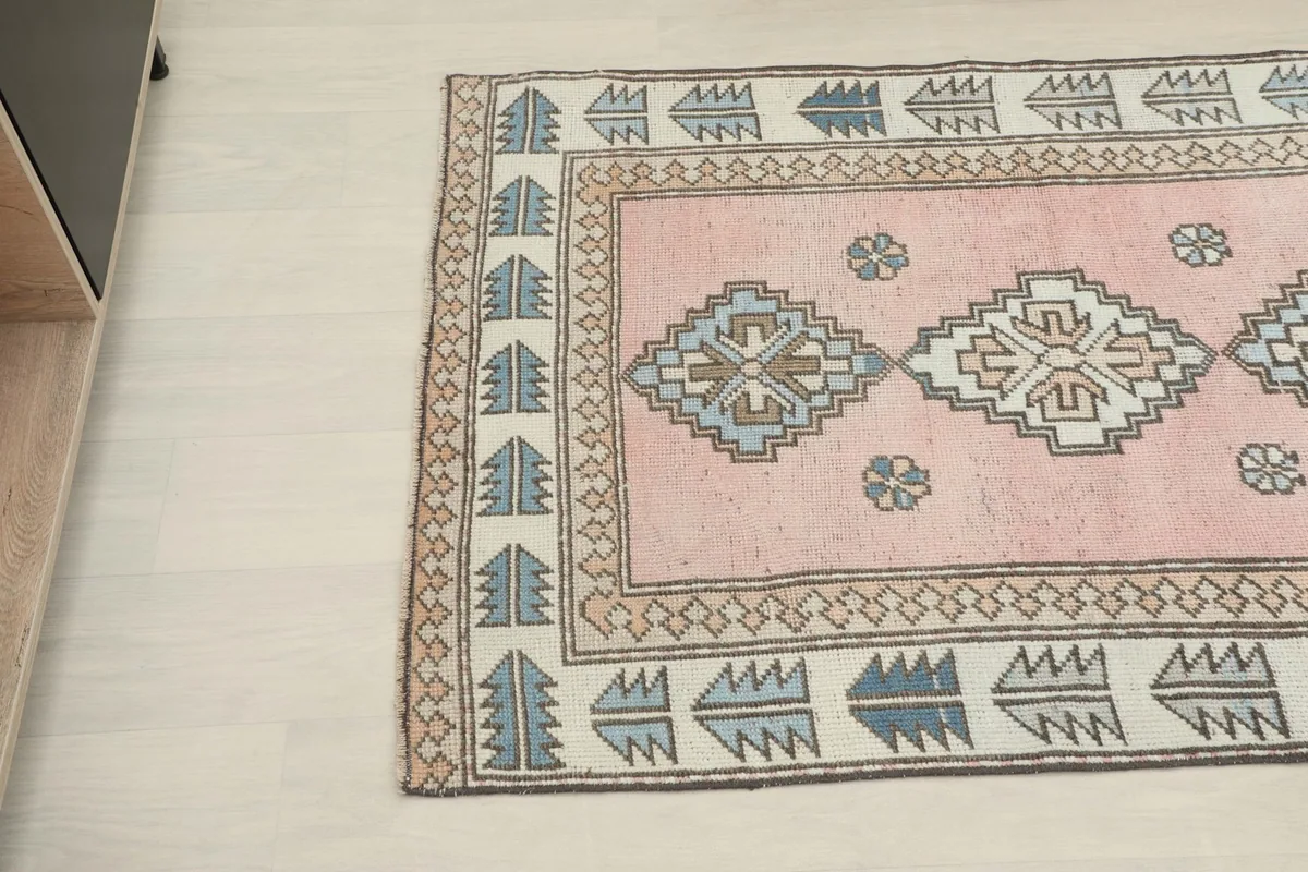 Overhead angled view showing the rug's full length and geometric border motifs