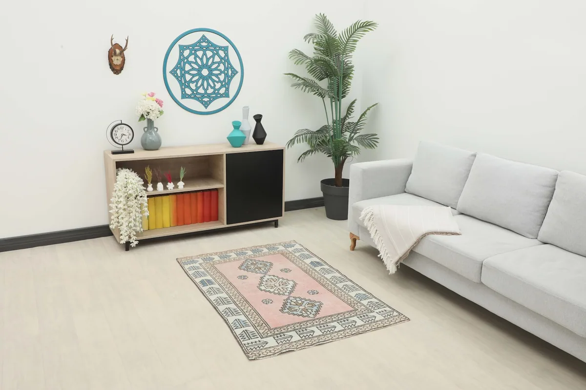 Rose tribal rug placed in a modern living room setting with a light sofa