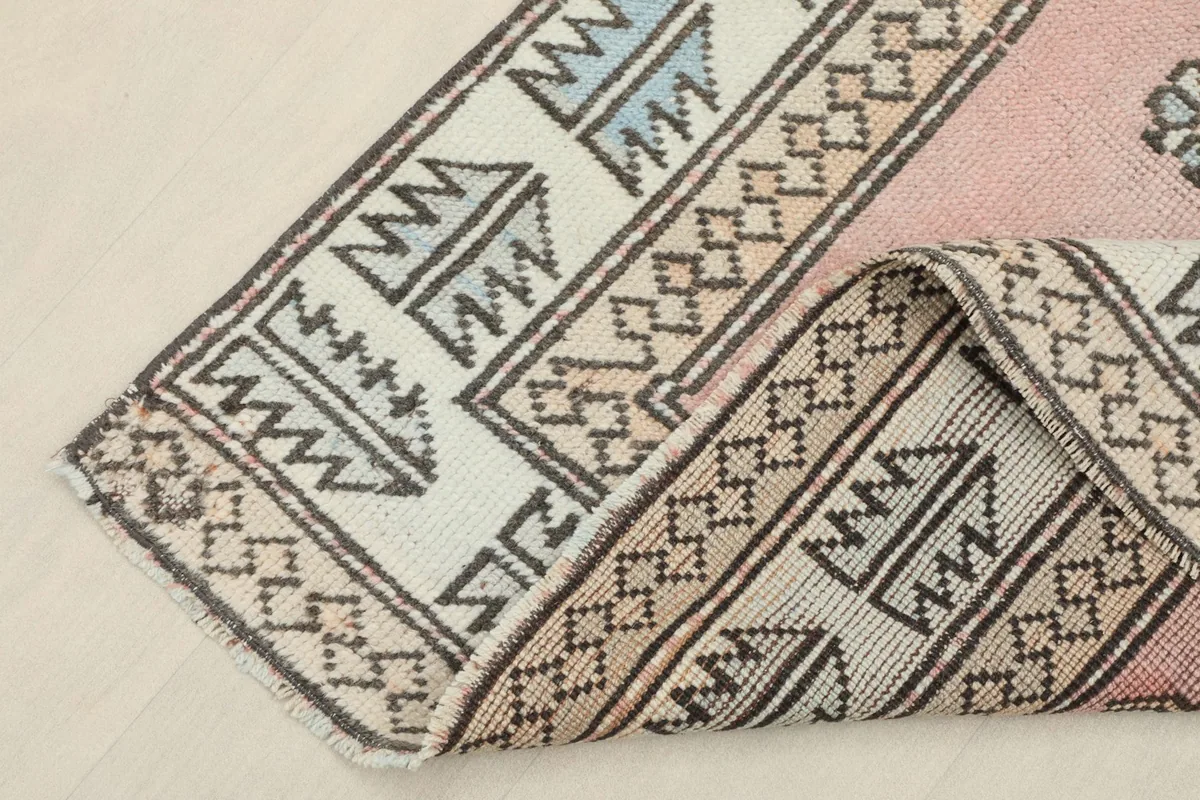 View of the rug with one corner folded, showing the pile and fringe details