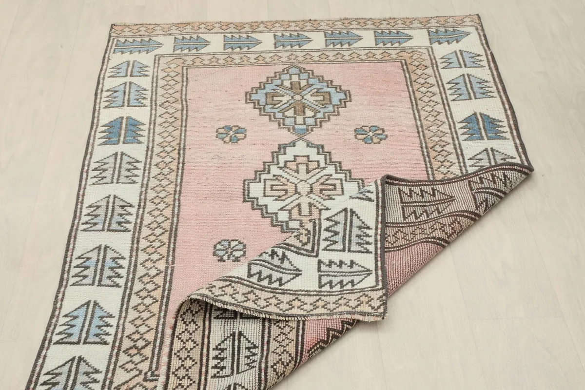 Rug partially folded to display the reverse side and the hand-knotted construction