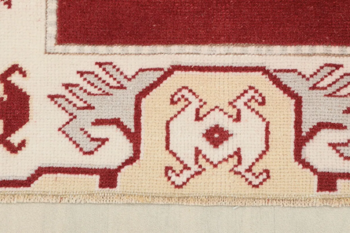 Close-up of the intricate tribal patterns within the ivory and beige border.