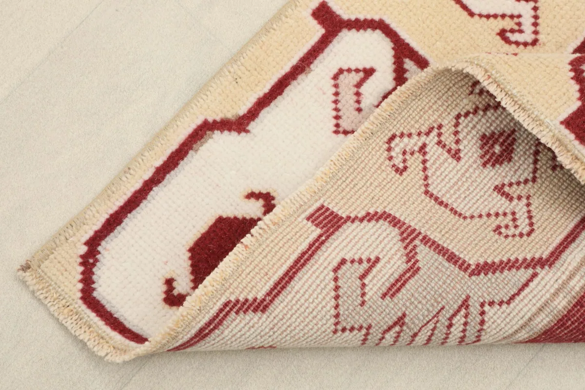 Corner of the runner folded to show the hand-knotted wool pile and cotton foundation.