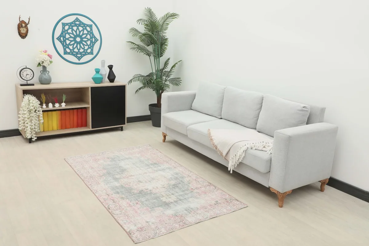 Vintage Anatolian rug displayed in a living room setting with a light gray sofa