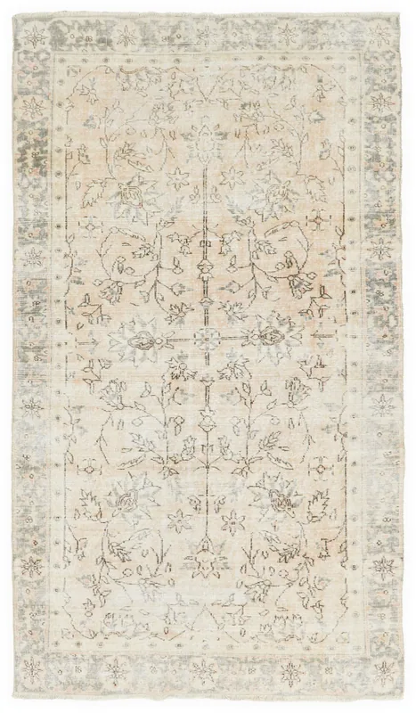 Full overhead view of the beige and charcoal floral vintage Anatolian area rug on a white background.